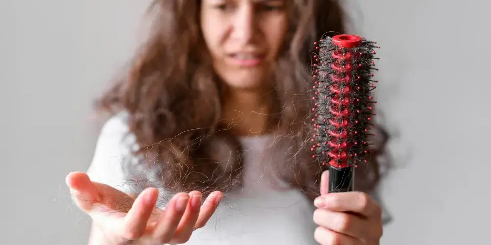 mulher jovem vendo que seu cabelo está caindo muito